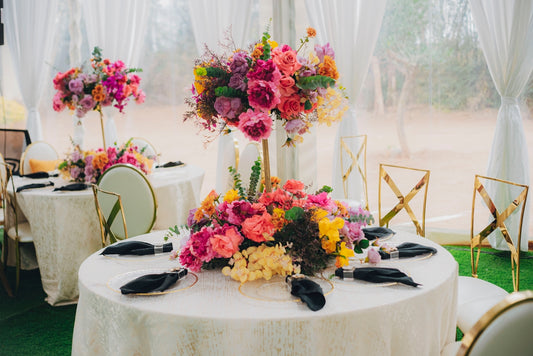 Elegant tables with vibrant floral centerpieces at an event.