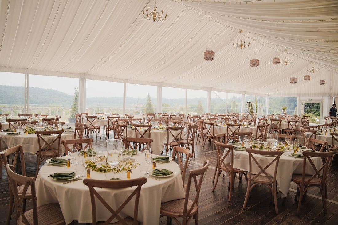 Elegant wedding reception tent with round tables and chairs