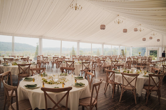 Elegant wedding reception tent with round tables and chairs
