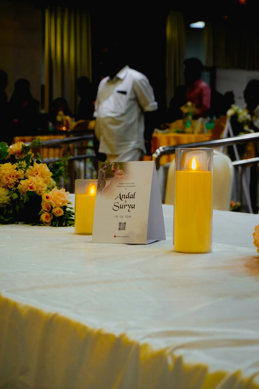 Table with candles and floral arrangement at an event.